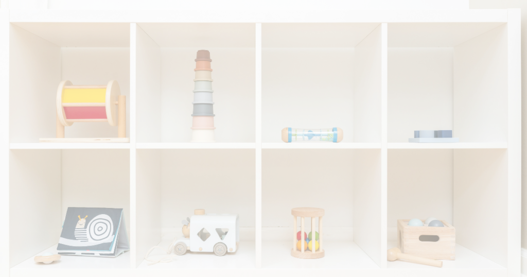 A view at a low montessori style shelf in a kids room. There are 8 cubbies with a toy in each cubby
